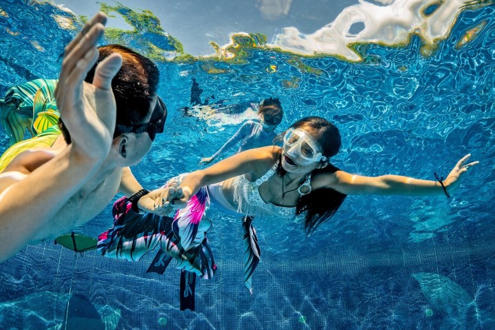 a couple of people swimming in a pool of water